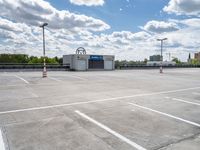 a parking lot with a store front and parking spaces in it on a partly cloudy day