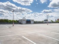 a parking lot with a store front and parking spaces in it on a partly cloudy day