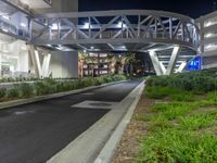 a view of a road and an overpass with traffic passing through it by buildings