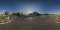 a wide view of a parking lot in the middle of the sun, with a sign for no parking