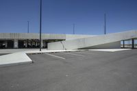 a parking lot with a tall ramp extending from it to the side on which an entrance is