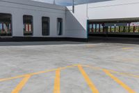 an empty parking lot is shown with several windows and a yellow line across the sidewalk