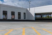 an empty parking lot is shown with several windows and a yellow line across the sidewalk