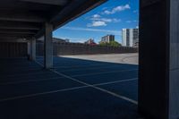 an empty parking lot in a city with tall buildings behind it on a clear day