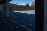 an empty parking lot in a city with tall buildings behind it on a clear day