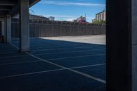 an empty parking lot in a city with tall buildings behind it on a clear day