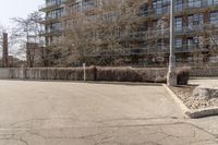 a stop sign in the middle of a street near a fence and tree line building