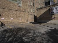 a parking lot with an empty red stop sign in front of a tall brick building