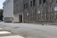 two parking meters on the side of a large building next to a street with parking spaces and several signs