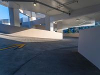 an empty parking lot on the roof of a building near a park and a hill