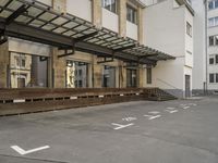 an empty building with signs on the street and people on bikes in traffic passing by