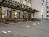 an empty building with signs on the street and people on bikes in traffic passing by