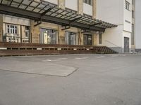 an empty building with signs on the street and people on bikes in traffic passing by