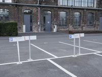 several parking spaces are set up outside a building for public use, with no parking sign posts on them