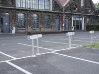 several parking spaces are set up outside a building for public use, with no parking sign posts on them