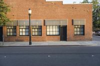 the building has several windows on it and a lamp pole in front of it,