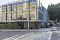 a large building with many windows next to a street sign on the side of the road