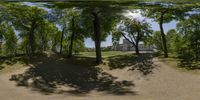 a 360 - panorama is shown through some trees and leaves on a path near a house