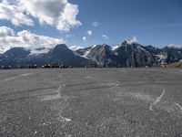 a paved circular field in front of snowy mountains with a view of snow capped mountains