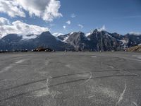 a paved circular field in front of snowy mountains with a view of snow capped mountains