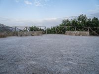 a paved driveway overlooks the water in a mountainous area with green trees on both sides