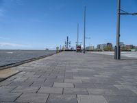 the path by the water has been paved with bricks and flags on it and flags along it