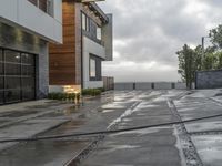 a paved patio near a building with concrete and wood details on the outside of the house