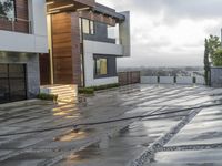 a paved patio near a building with concrete and wood details on the outside of the house