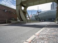 a paved road leading to an arena under construction with stairs at the top of the street