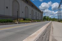 the road is paved and empty near buildings and wires and poles are all present at this time