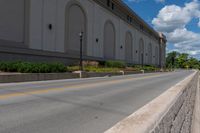 the road is paved and empty near buildings and wires and poles are all present at this time