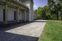 a very long paved sidewalk on a big nice day outside the mansion area at home