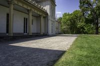 a very long paved sidewalk on a big nice day outside the mansion area at home