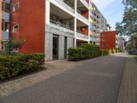 a long paved sidewalk in front of a multi - story building with many windows on each level