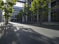 a paved street in the city with a bench in the middle of it and two people walking on both side