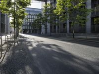 a paved street in the city with a bench in the middle of it and two people walking on both side