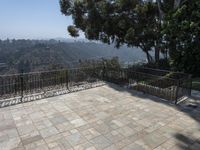 a paved walkway that stretches into the distance, near trees, and hills as well