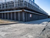 the pedestrian walking underneath the bridge goes from the parking lot to the other side of the building