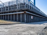 the pedestrian walking underneath the bridge goes from the parking lot to the other side of the building