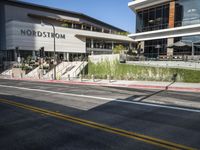 pedestrians are walking along a street outside an outdoor retail store or store building with the name nordstrom in front