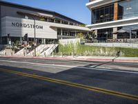 pedestrians are walking along a street outside an outdoor retail store or store building with the name nordstrom in front