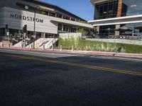 pedestrians are walking along a street outside an outdoor retail store or store building with the name nordstrom in front