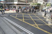 people are crossing the street at an intersection with a tram going down it's side