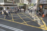 people are crossing the street at an intersection with a tram going down it's side