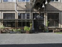 people sit on benches outside the building that used to house the business and coffee shop