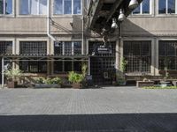 people sit on benches outside the building that used to house the business and coffee shop