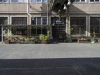 people sit on benches outside the building that used to house the business and coffee shop