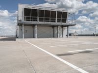 two people walk across the tarmac of an airplane hangar on a cloudy day in flight