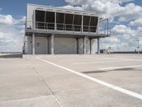 two people walk across the tarmac of an airplane hangar on a cloudy day in flight