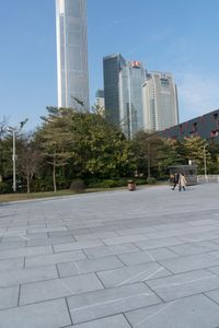 a group of people are walking around in the city on a sunny day with skyscrapers in the background